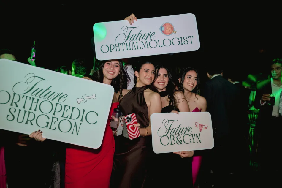 Graduadas con carteles de su carrera